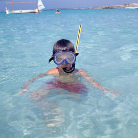 Nin a la mar amb careta i tub