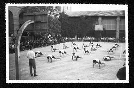 Alumnes homes fent exercicis de gimnàstica al pati